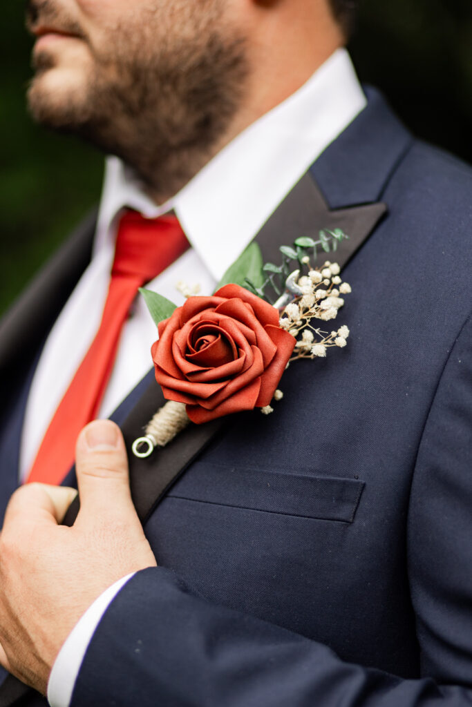 The groom is wearing a boutonniere with a wrench inside it.